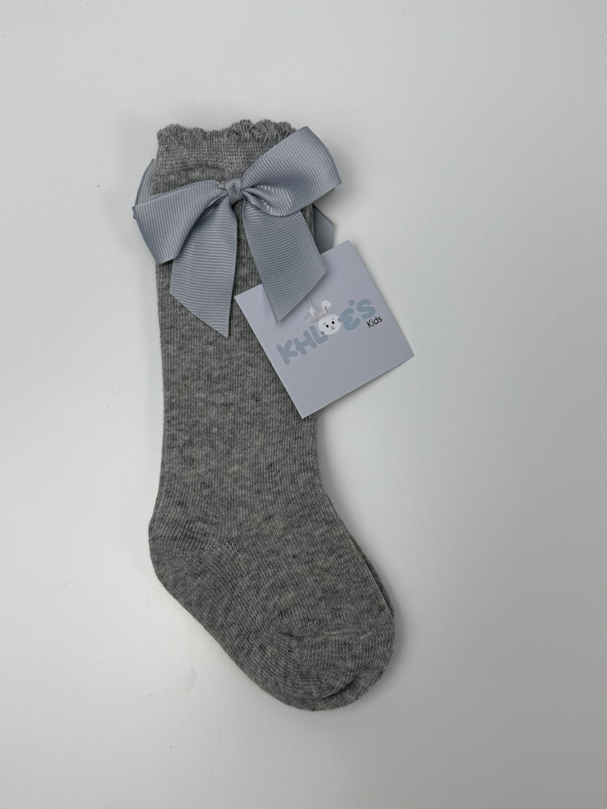 Gray sock with a bow and a label on a light gray background